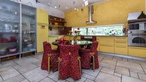 A kitchen with a dining table, chairs, and a stove. - B&B La Colombera (Lessona)