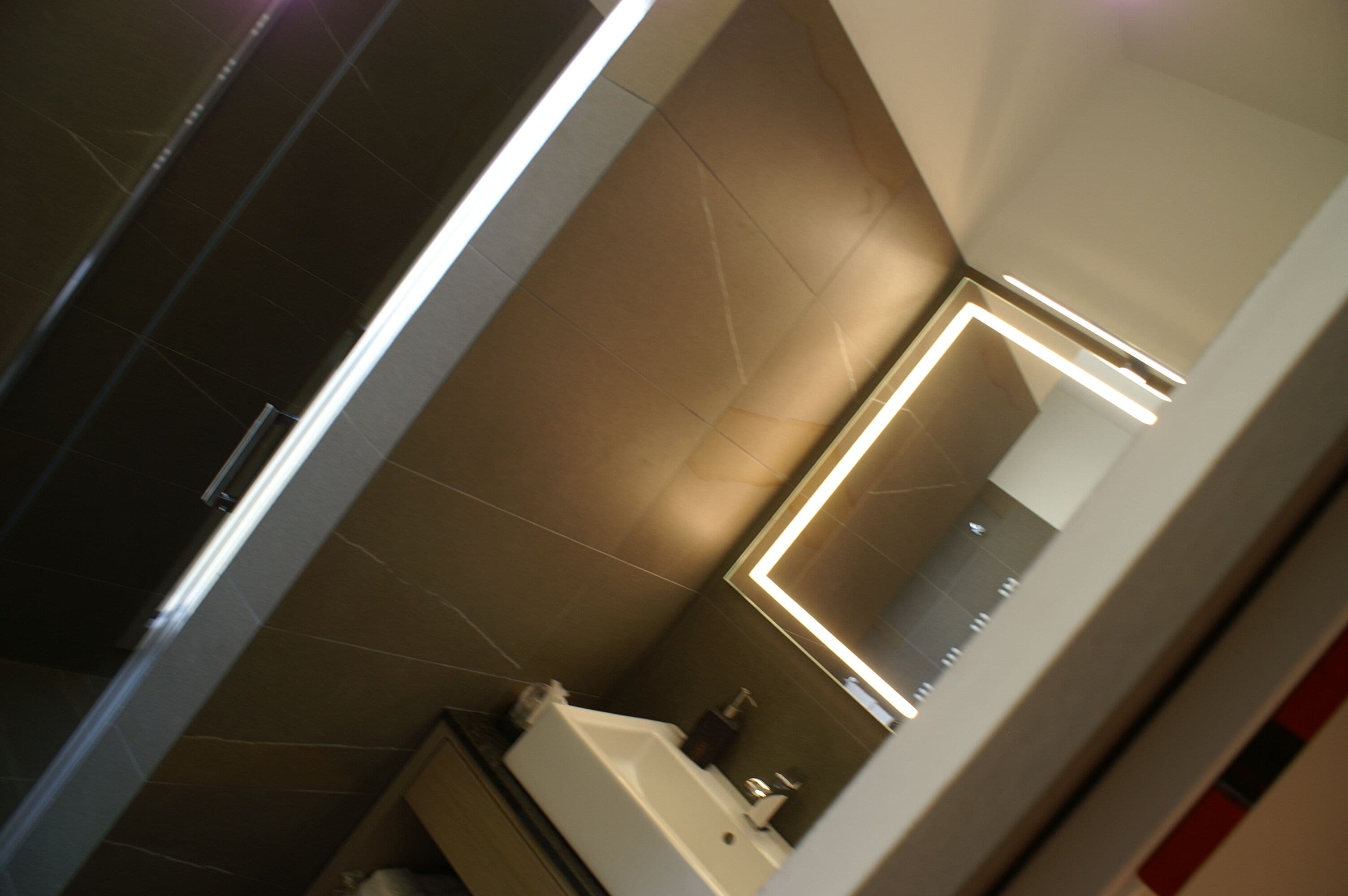 Een moderne badkamer met een grote spiegel, een bad en een douchehoek.