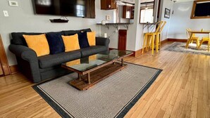 Ein Wohnzimmer mit Sofa, Couchtisch und Essbereich mit Stühlen.
