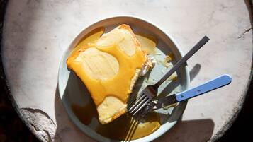 A plate with a slice of toast and a fork.