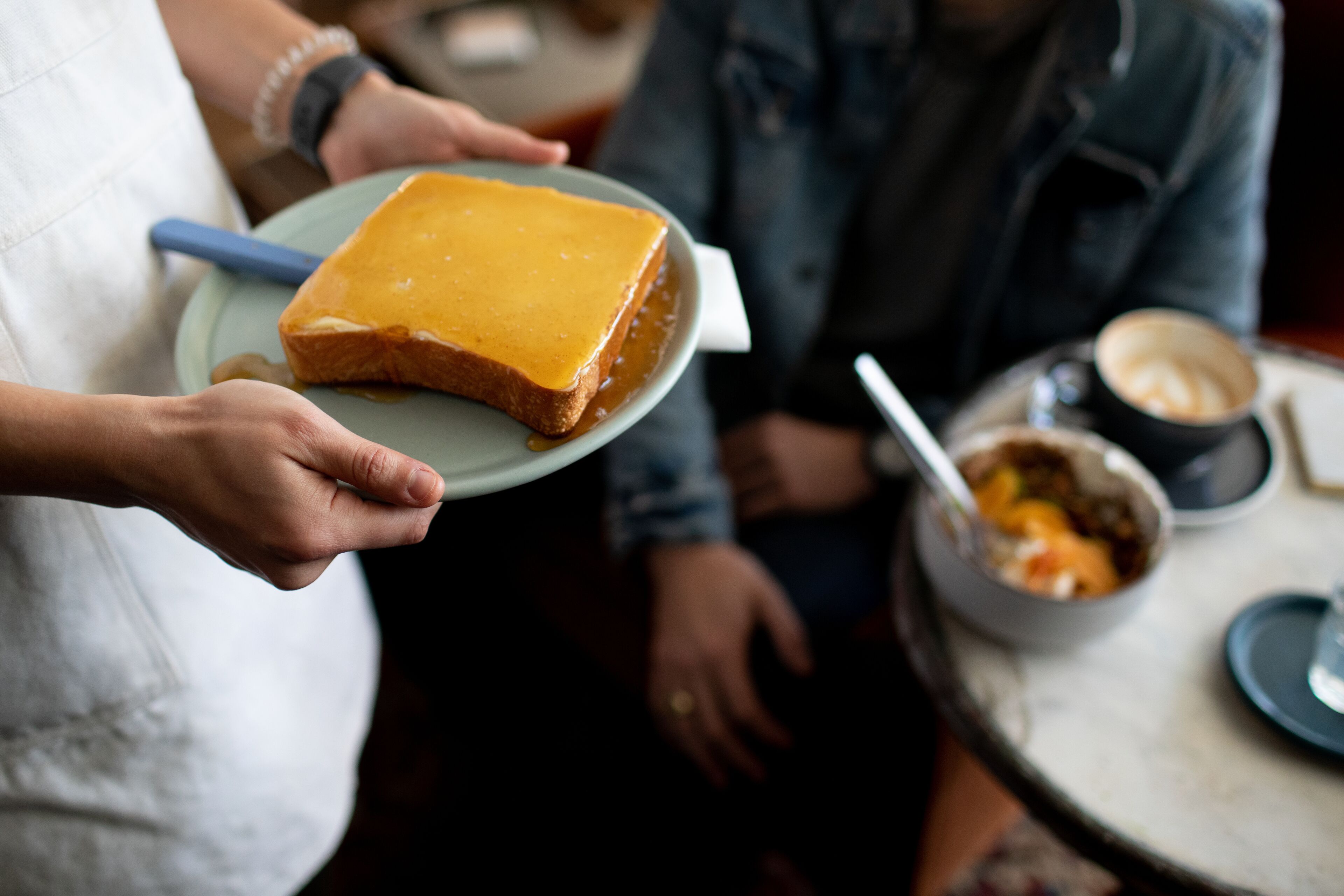 A person holding a plate with a slice of cake.