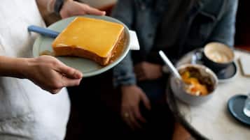 A person holding a plate with a slice of cake.
