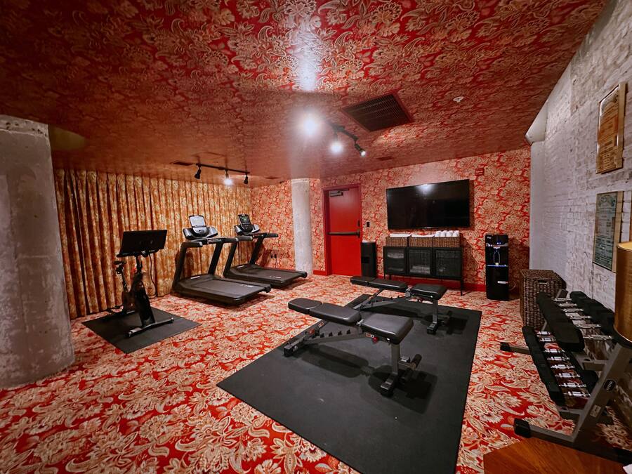 A gym with treadmills, benches, and weight equipment.