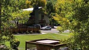 Eine Lodge mit einer großen Terrasse, einer überdachten Veranda und Blick auf einen bewaldeten Berg.