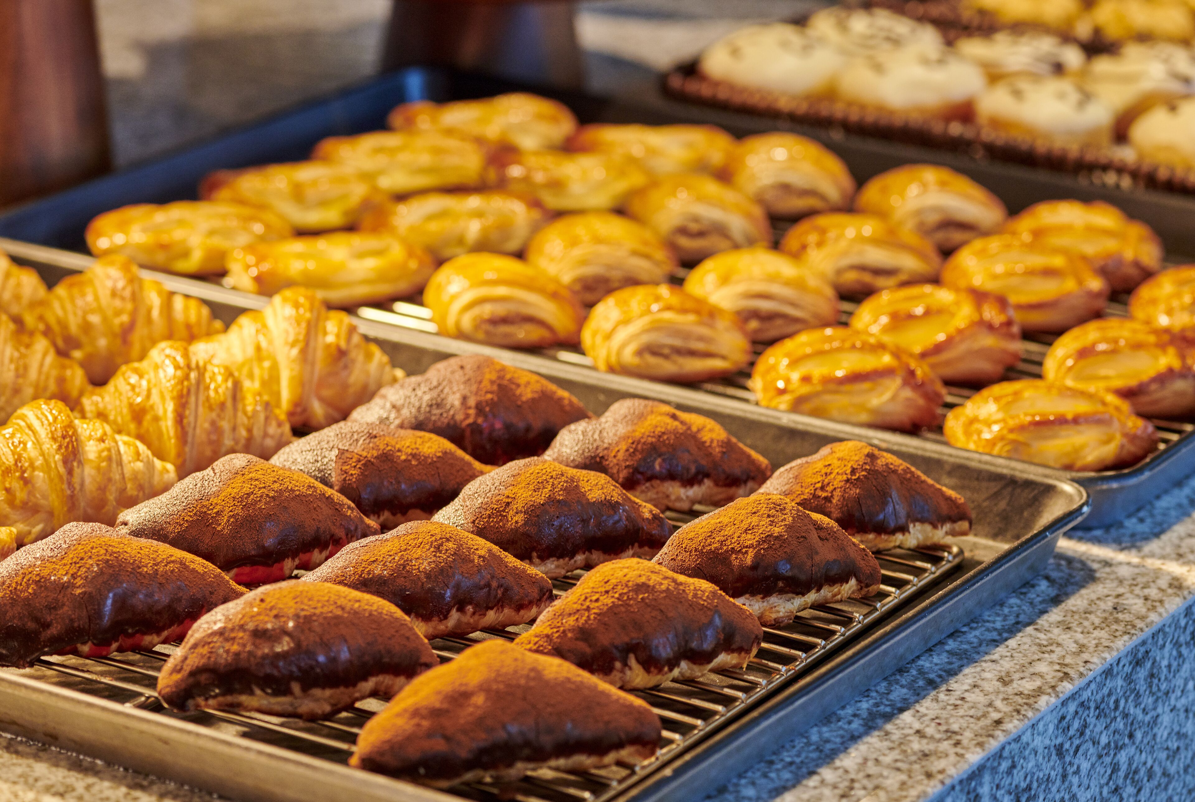 A variety of baked goods on display, including pastries and bread.
