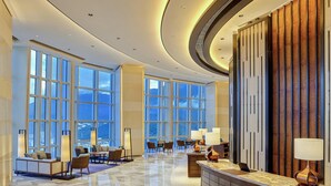 A spacious lobby with large windows, a reception desk, and seating areas. - Hyatt Regency Shenzhen Yantian (Shenzhen)