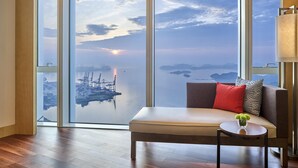 A modern room with a large window offering a view of a port and distant islands. - Hyatt Regency Shenzhen Yantian (Shenzhen)