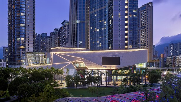 A modern hotel with a prominent cylindrical tower, multiple high-rise buildings, and a well-lit entrance area. - Hyatt Regency Shenzhen Yantian (Shenzhen)