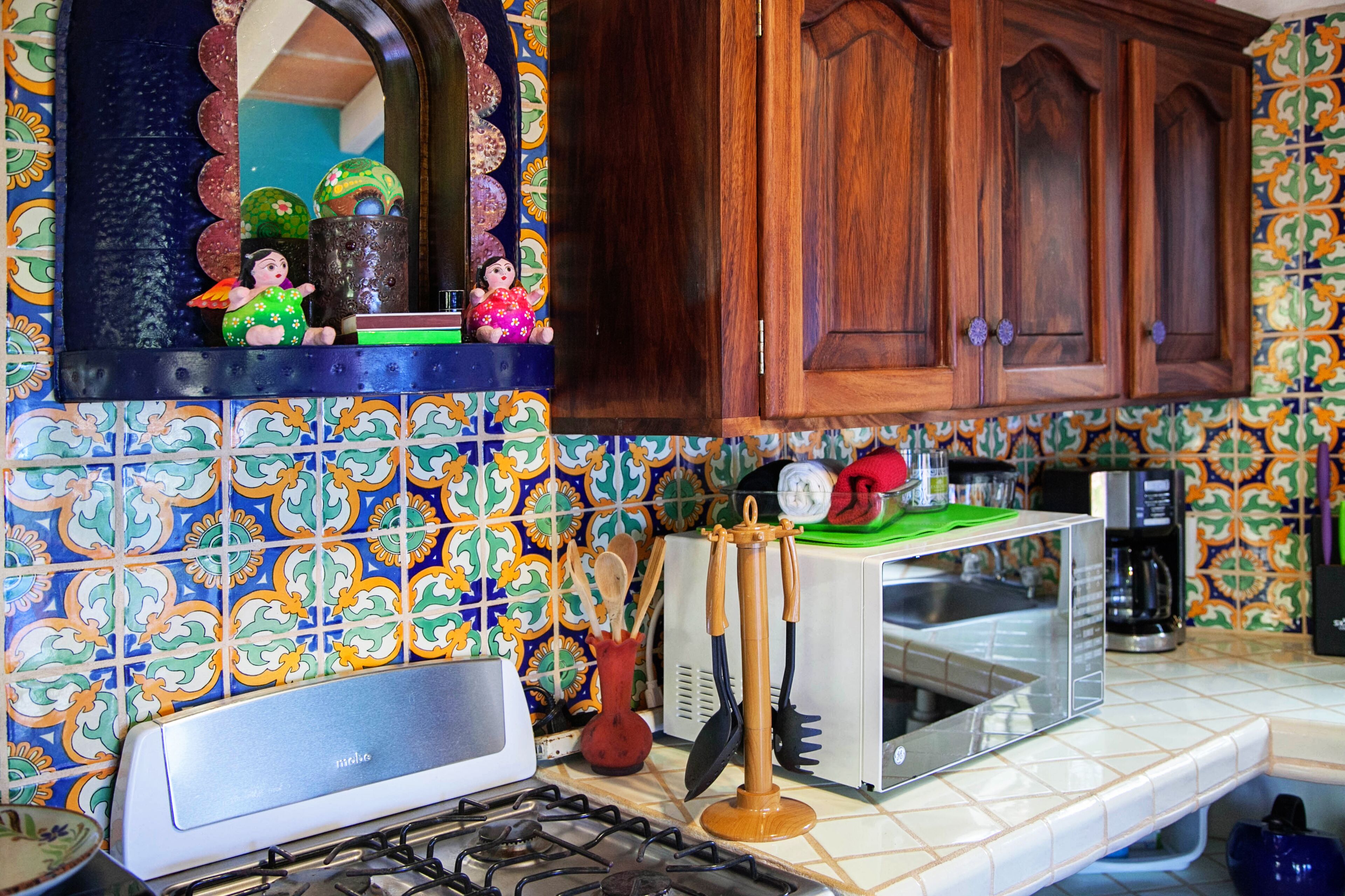 A kitchen with a gas stove, a microwave, and a coffee maker.