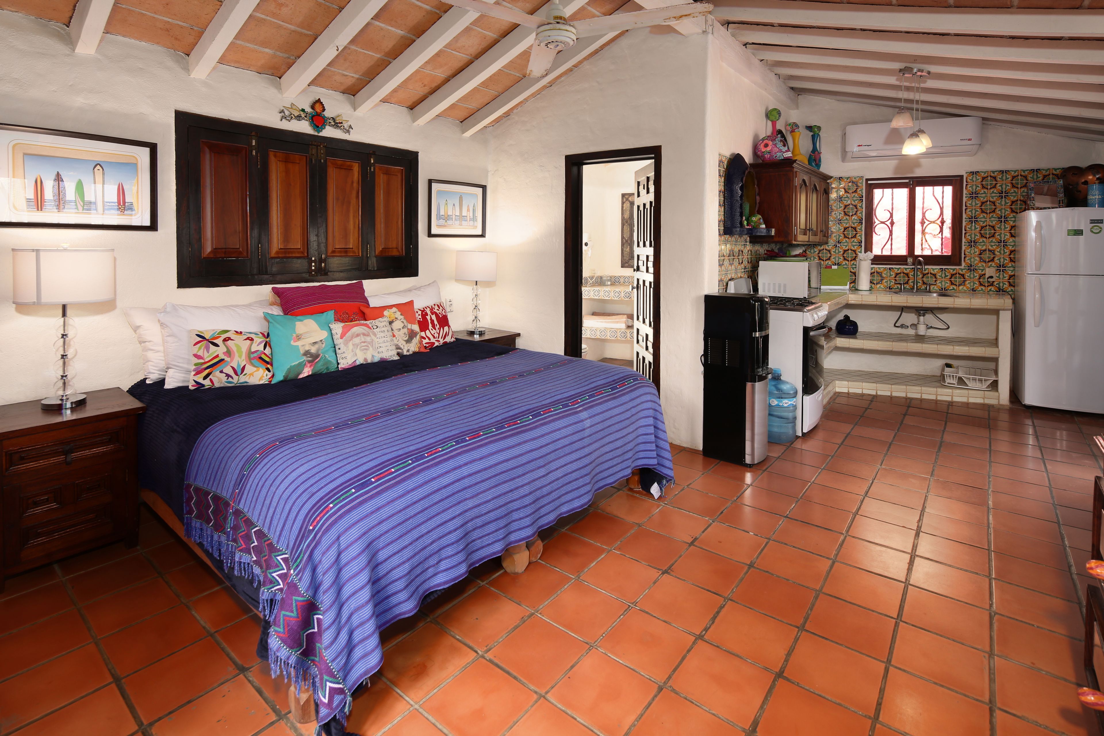 Un dormitorio con cama, mesitas de noche, cómoda y ventana.