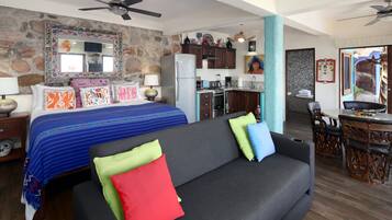 Une chambre d’hôtel moderne dotée d’un grand lit, d’un canapé, d’une kitchenette et d’un coin repas.