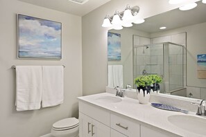 A modern bathroom with two sinks, a large mirror, and a glass shower enclosure. - Southern Adobe by RedAwning (Washington)