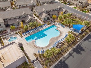 An aerial view of a residential area with a swimming pool, lounge chairs, and palm trees. - Southern Adobe by RedAwning (Washington)
