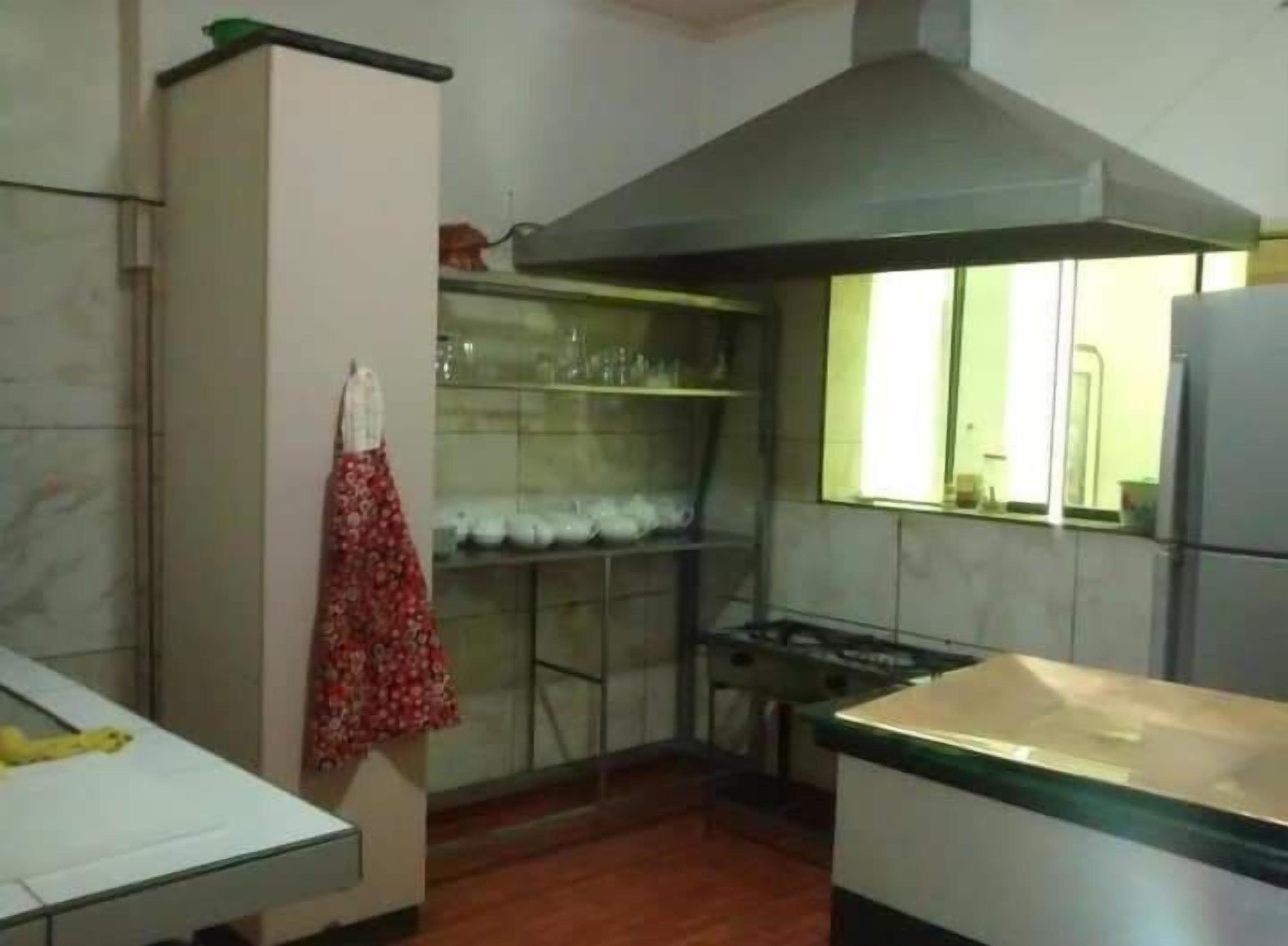 A kitchen with a stove, a sink, and a window.