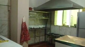 A kitchen with a stove, a sink, and a window.