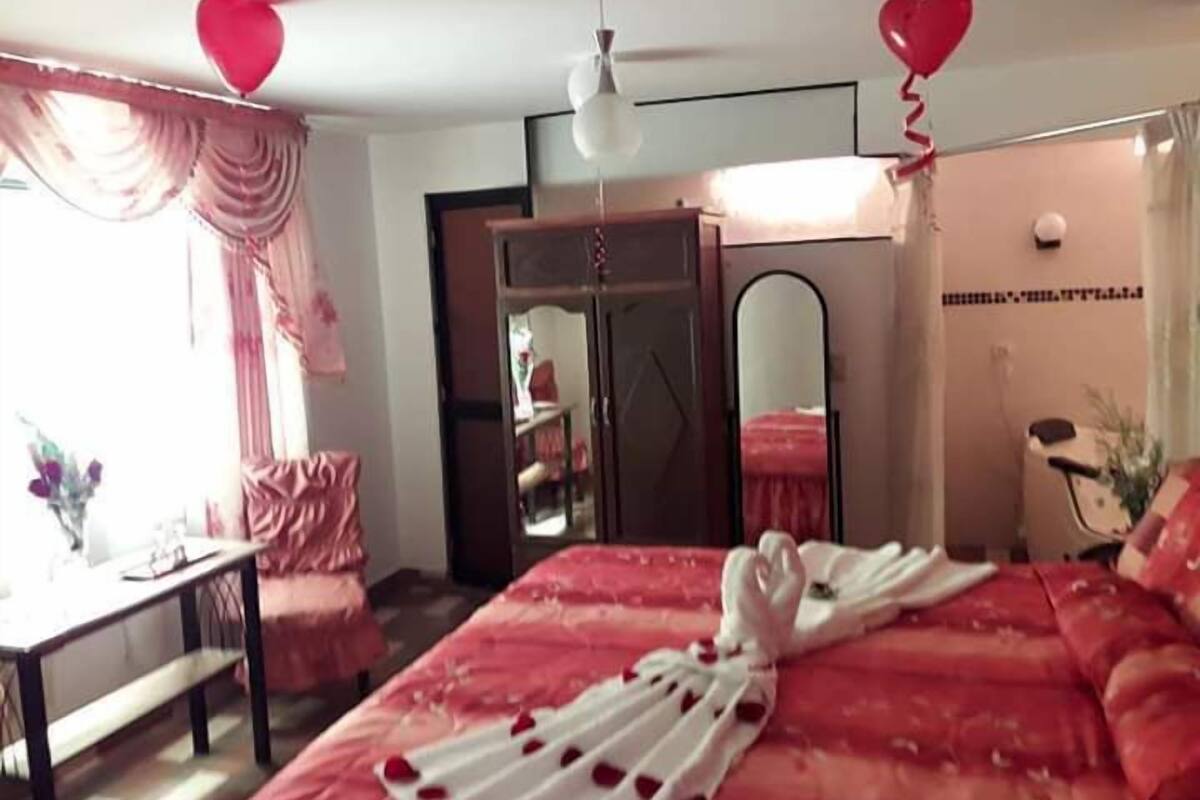 Une chambre d’hôtel comprenant un lit, un bureau, une chaise, une armoire et un miroir.