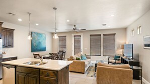 Una cocina amplia con una isla grande, armarios de madera y un comedor con sillas y una mesa.