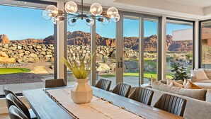 Un espace repas moderne avec une grande table, des chaises et un vase rempli de plantes.