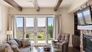A living room with a sofa, armchair, and a fireplace.