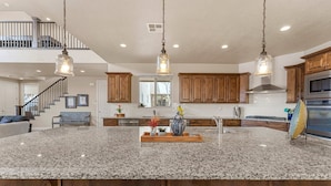 A spacious kitchen with granite countertops, wooden cabinets, and a central island. - Paintbrush Retreat #65 by RedAwning (Ivins)
