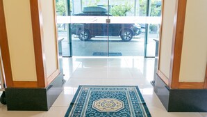 A hallway with a patterned rug leading to a glass door. - Palacio do Rio Hotel (Teresina)