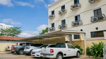 A multi-story building with a parking area.