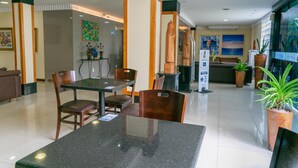 A hotel lobby with a reception desk, seating area, and a large window with a view. - Palacio do Rio Hotel (Teresina)