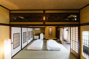 Ein traditioneller japanischer Raum mit Tatami-Böden, Shoji-Schirmwänden und einer niedrigen Decke.