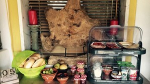 Un buffet pour le petit-déjeuner avec du pain, des fruits et des accompagnements.
