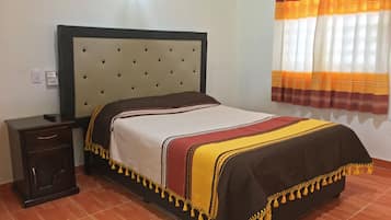 Habitación doble familiar | Edredón, muebles diferentes y espacio para trabajar con laptop