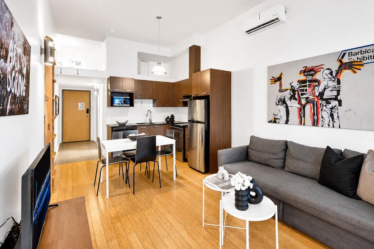 Estudio Deluxe, 1 cama Queen size y sofá cama, vista a la ciudad, mezzanine (The Main 202) | Área de sala de estar | Televisión de pantalla plana de 49 pulgadas con canales digitales