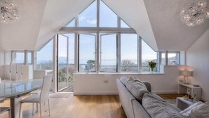 A spacious room with a large skylight, a modern dining area, and a comfortable seating area.