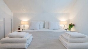 A hotel room with a large bed, two bedside tables, and a nightstand.