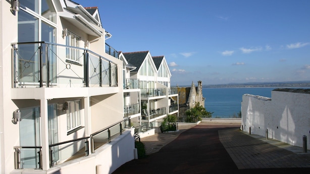 A modern hotel with multiple balconies overlooking a coastal view. - Indigo (St Ives)