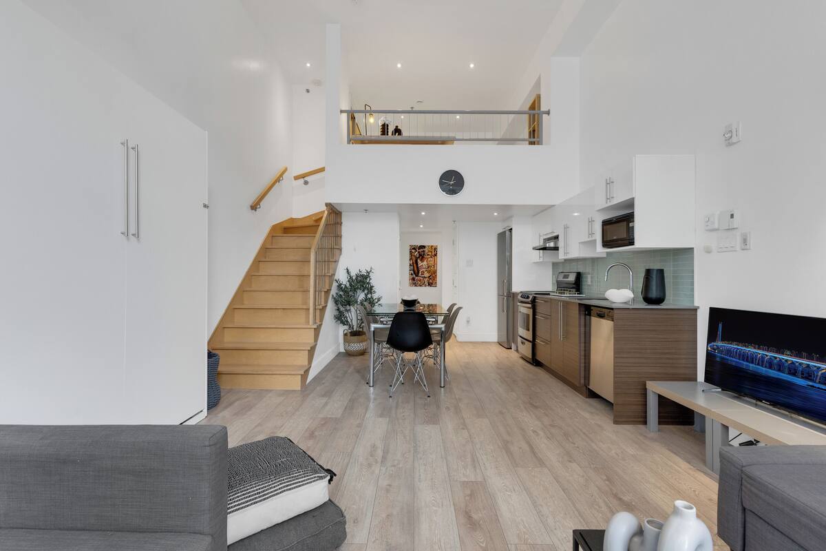 A modern apartment with a dining area, kitchen, and living room.