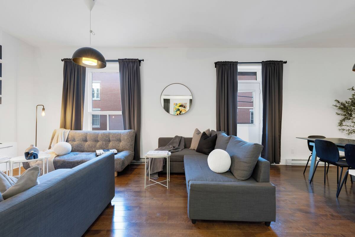 A modern living room with a sofa, a dining table, and a small side table.