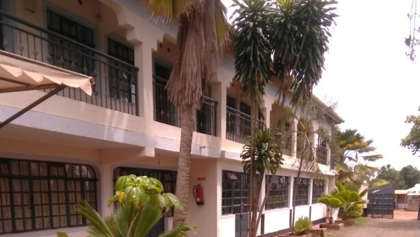 A building with multiple balconies, potted plants, and a fire extinguisher. - Usenge Sunset Resort (Usenge)