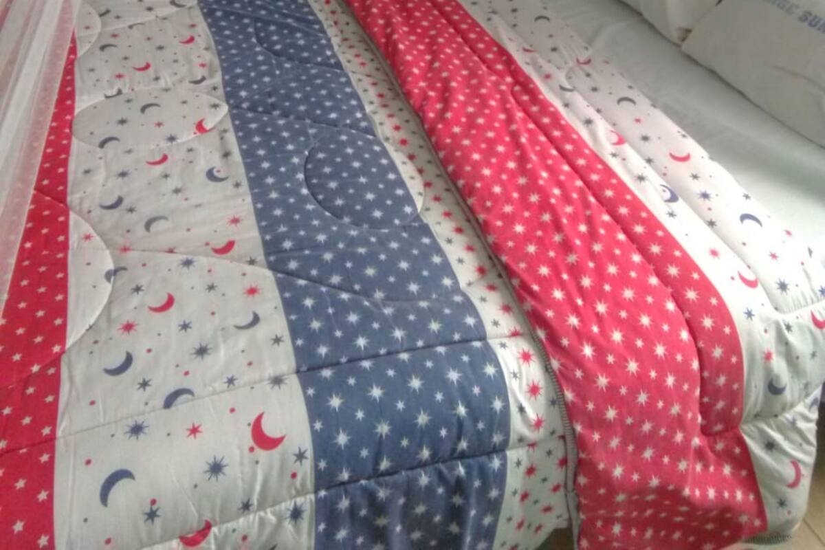 Una cama con dosel y colcha con estampado de estrella y creciente.