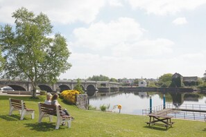 A riverside park with benches, a bridge, and a calm water body. - Apartment Sleeps 7 With Mezzanine (Birr)