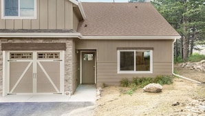 A two-story house with a garage, a front door, and a large window. - Hawkeye Ridge -- Ev 6189 3 Bedroom Condo by RedAwning (Estes Park)