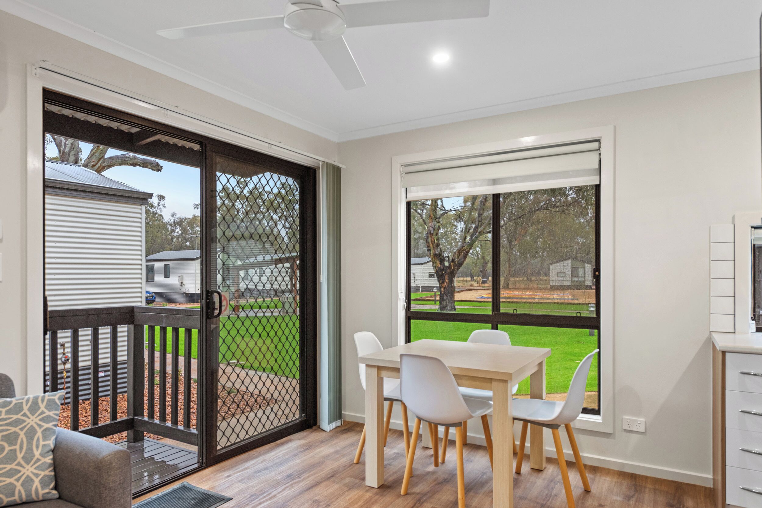 A modern kitchen with white cabinets and a large window.