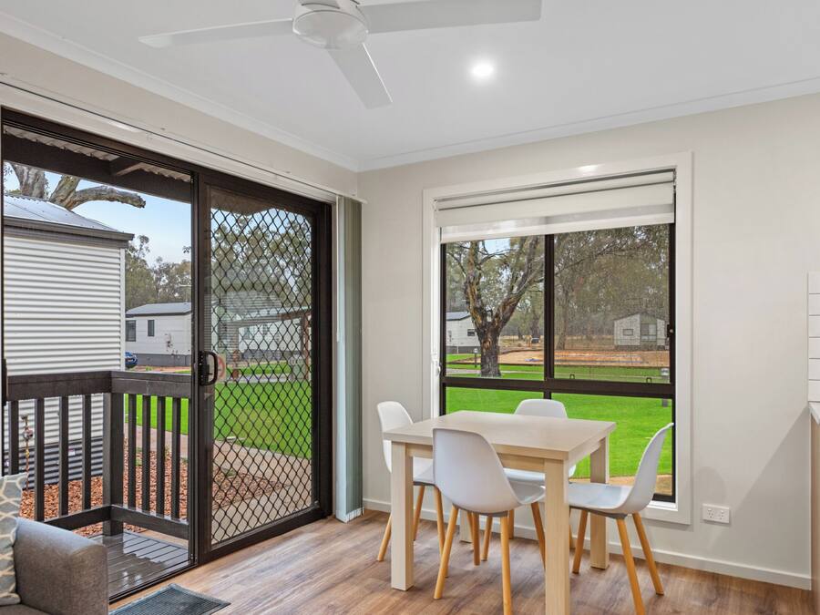 A modern kitchen with white cabinets and a large window.