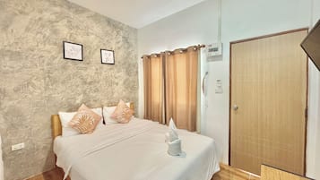 Relax in a serene space with a large bed, framed artwork, and a wooden door.