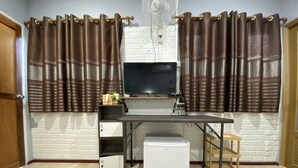 Una cocina compacta con refrigerador, un lavamanos pequeño y una encimera.