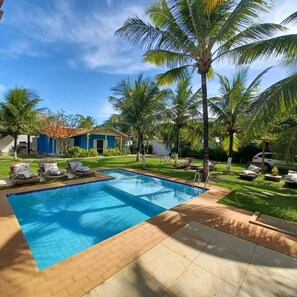 Ein Swimmingpool mit Liegestühlen und Palmen.