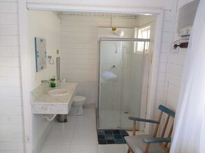 Ein kleines Badezimmer mit Dusche, Toilette und Waschbecken.
