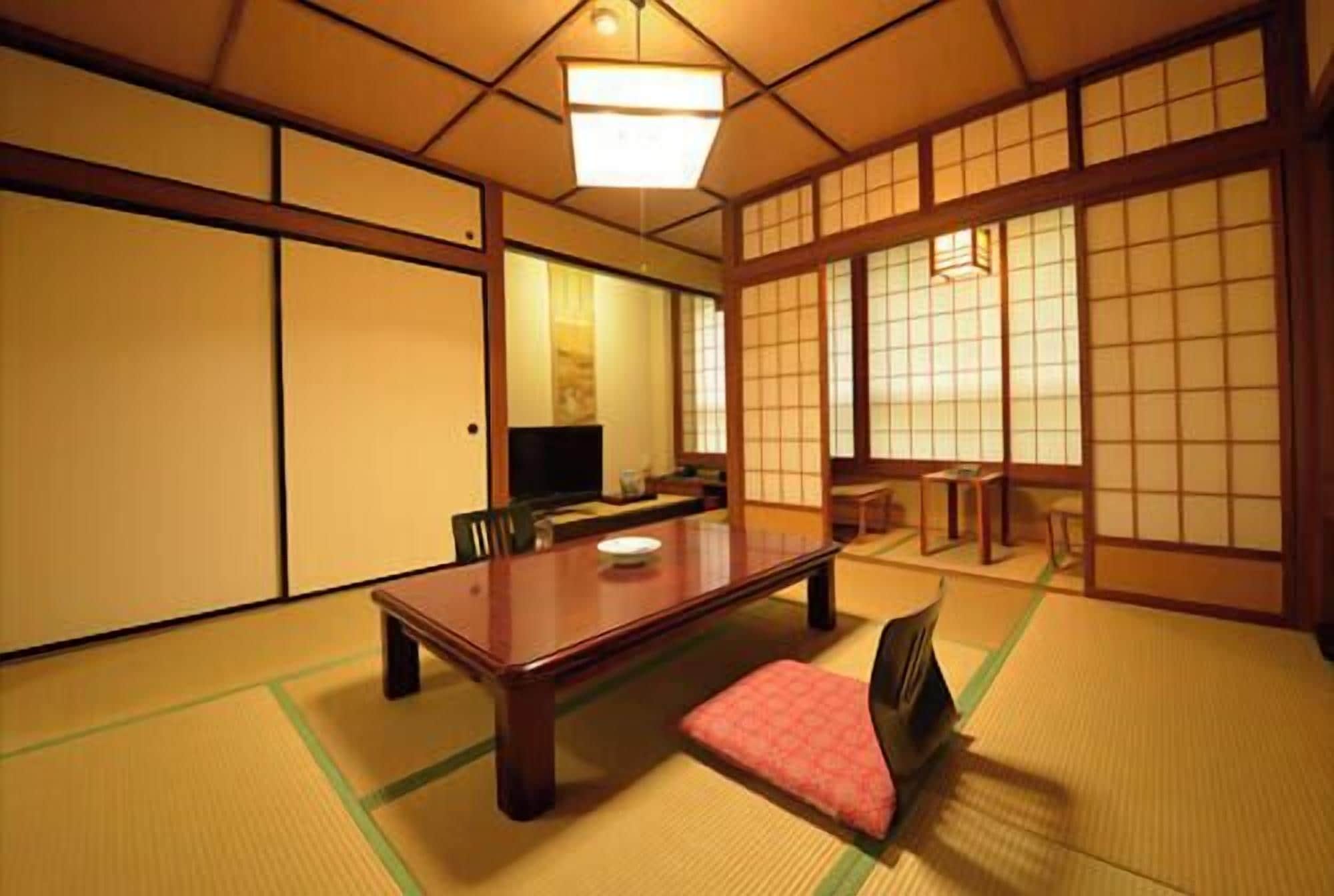 A traditional Japanese room with tatami flooring, a low table, and sliding doors.