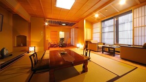 Una habitación japonesa tradicional con suelo de tatami, una mesa baja y puertas correderas.