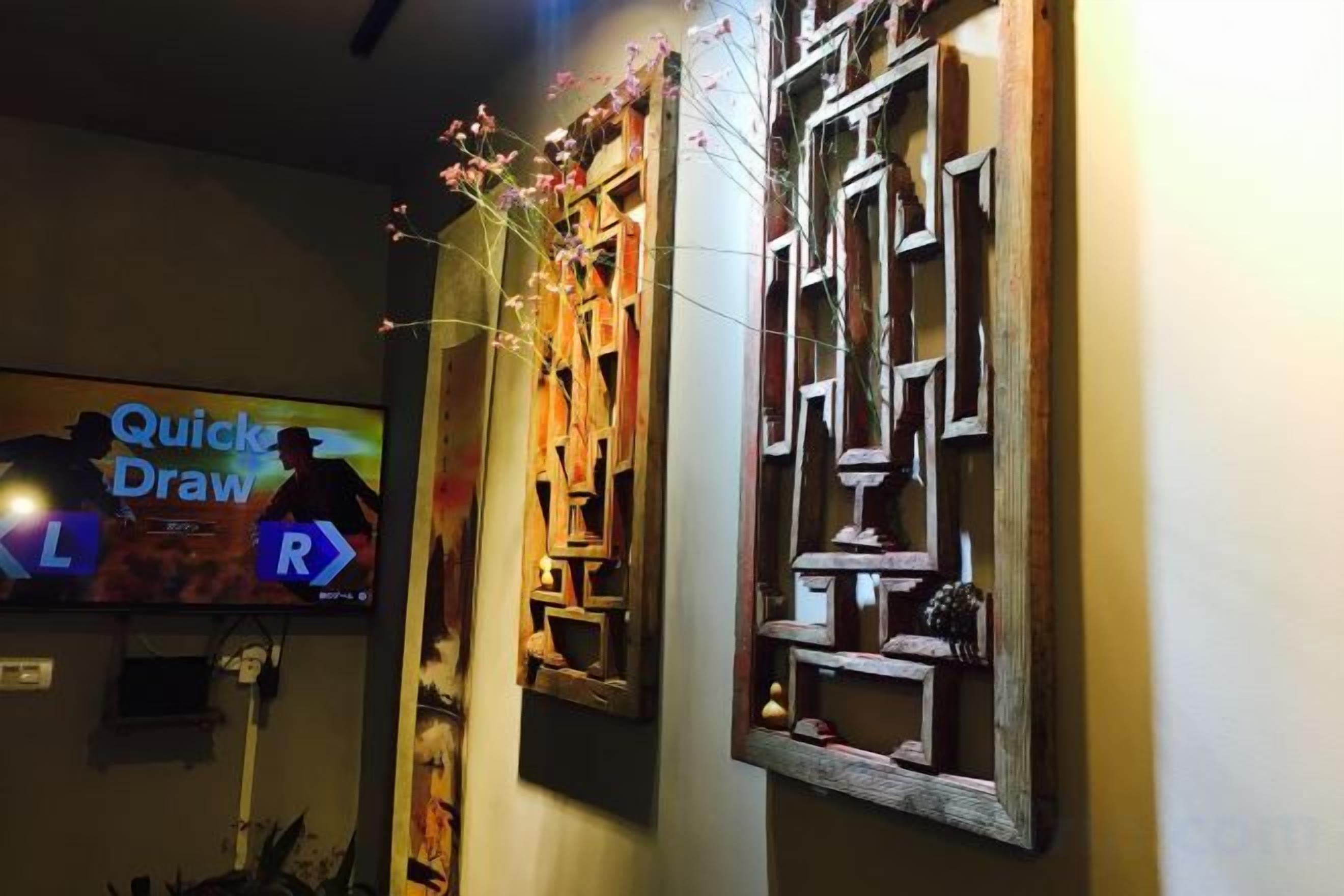 A wall with a television displaying 'Quick Draw' and decorative wooden panels with geometric patterns.