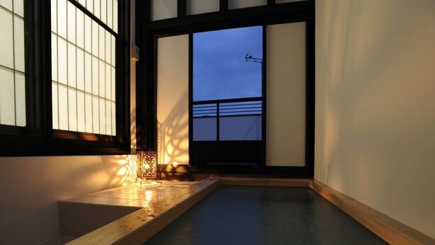 A room with a wooden bench, a small table, and a view of the sky through large windows. - Chouja Yashiki (Nanyo)